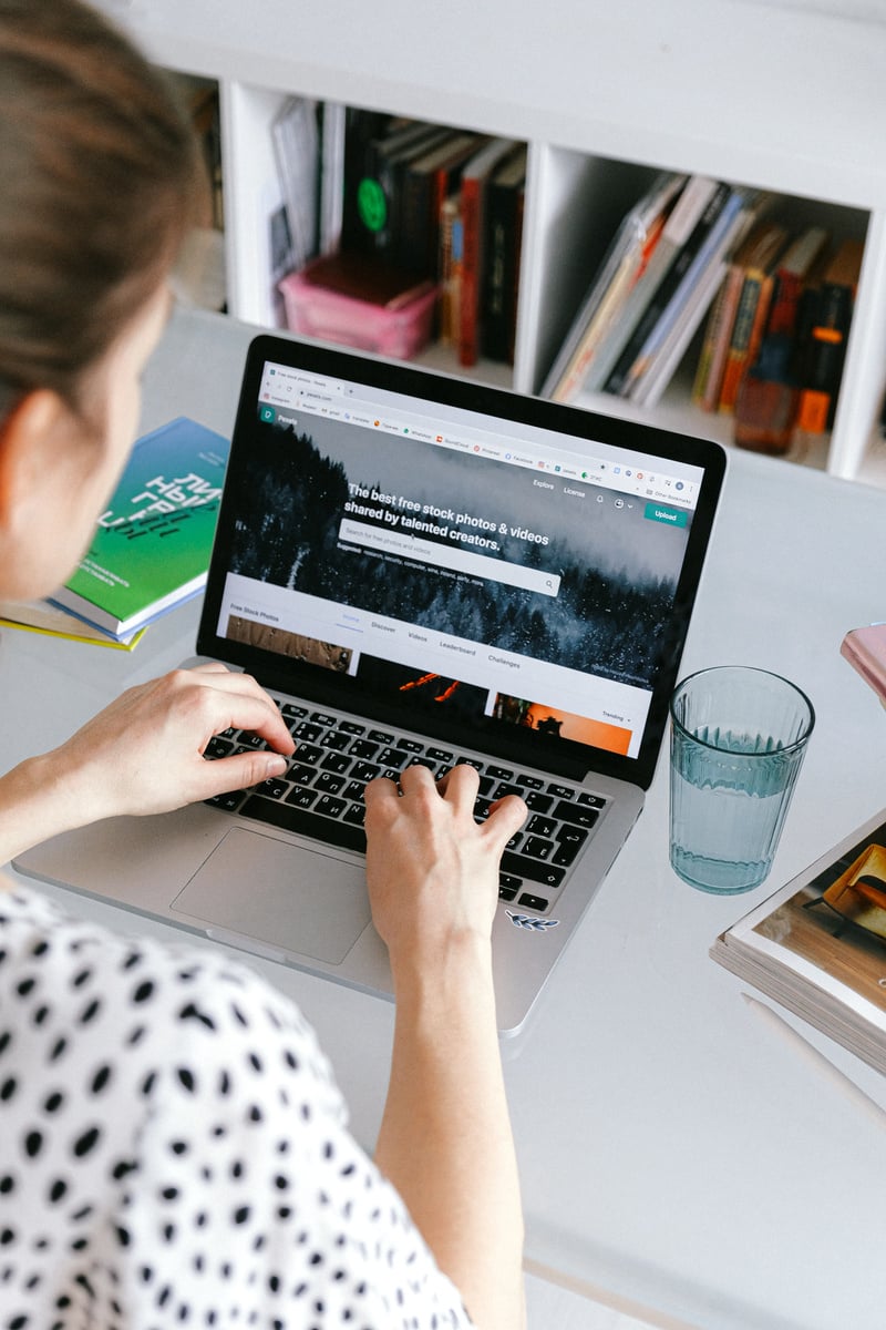 Person Using Macbook On White Table